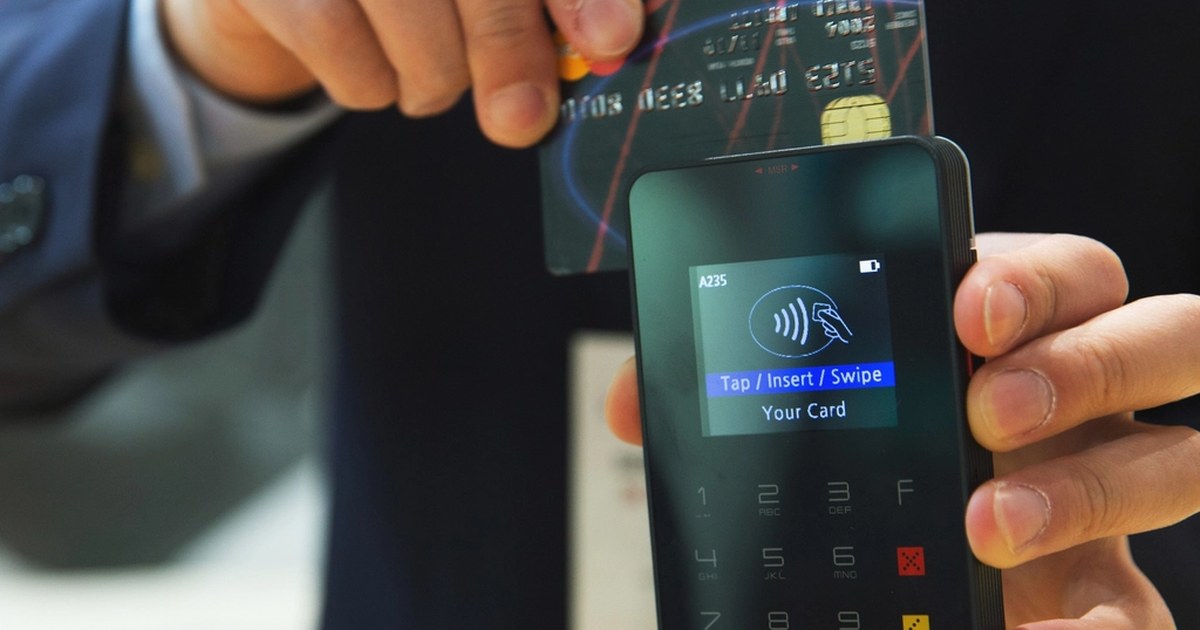 Hand inserting a payment card into a card reader terminal