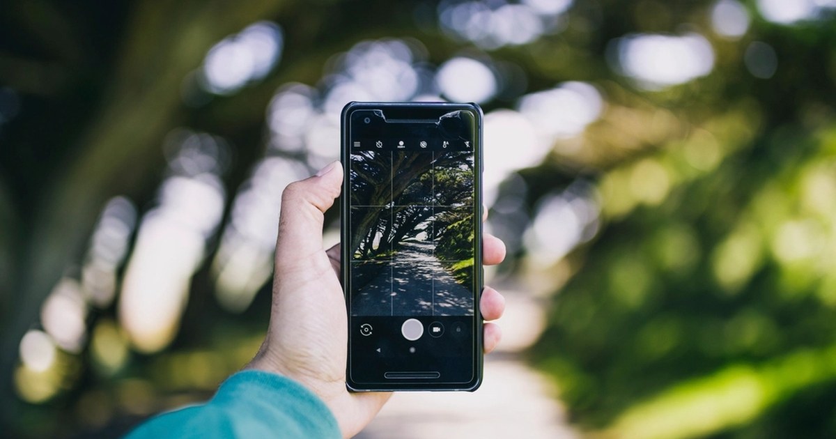 Person holding a smartphone, illustrating mobile online slot play under UK regulation.