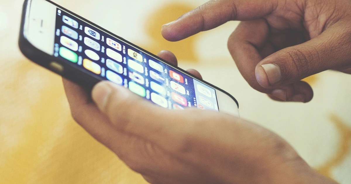 Person using a smartphone with apps on screen, illustrating online gambling adverts on mobile platforms