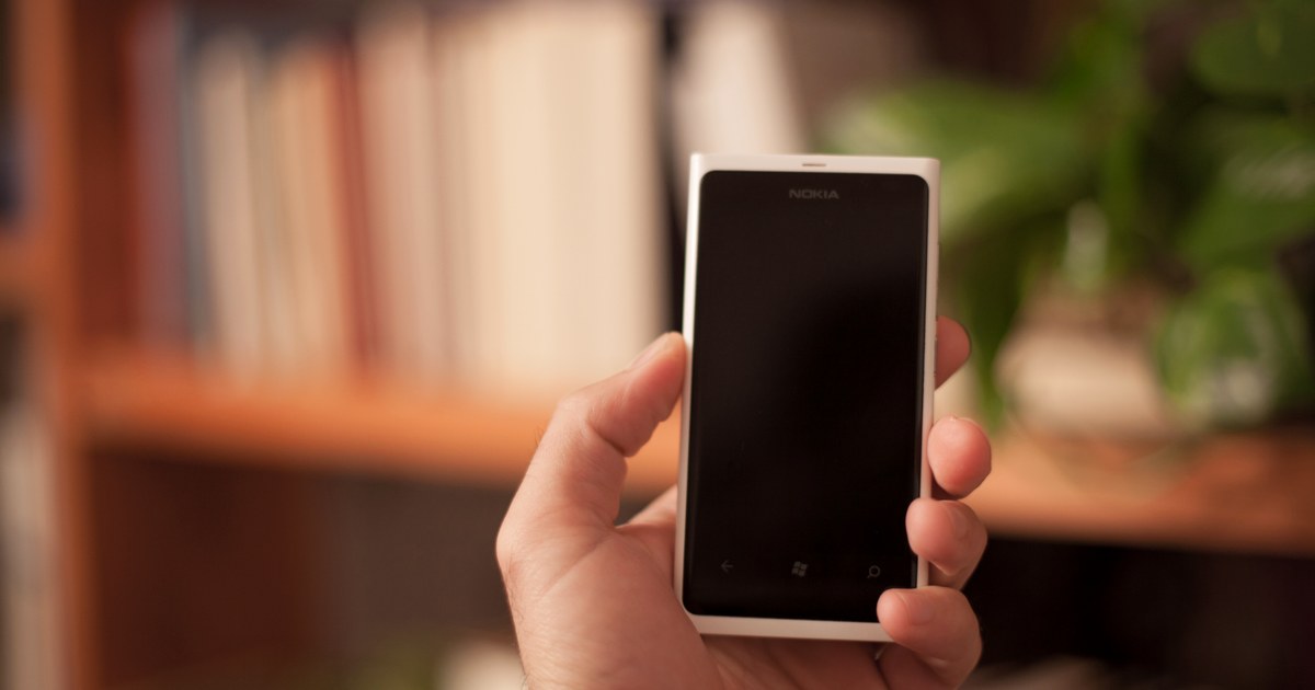 Person holding a smartphone, representing managing an online casino account and setting deposit limits