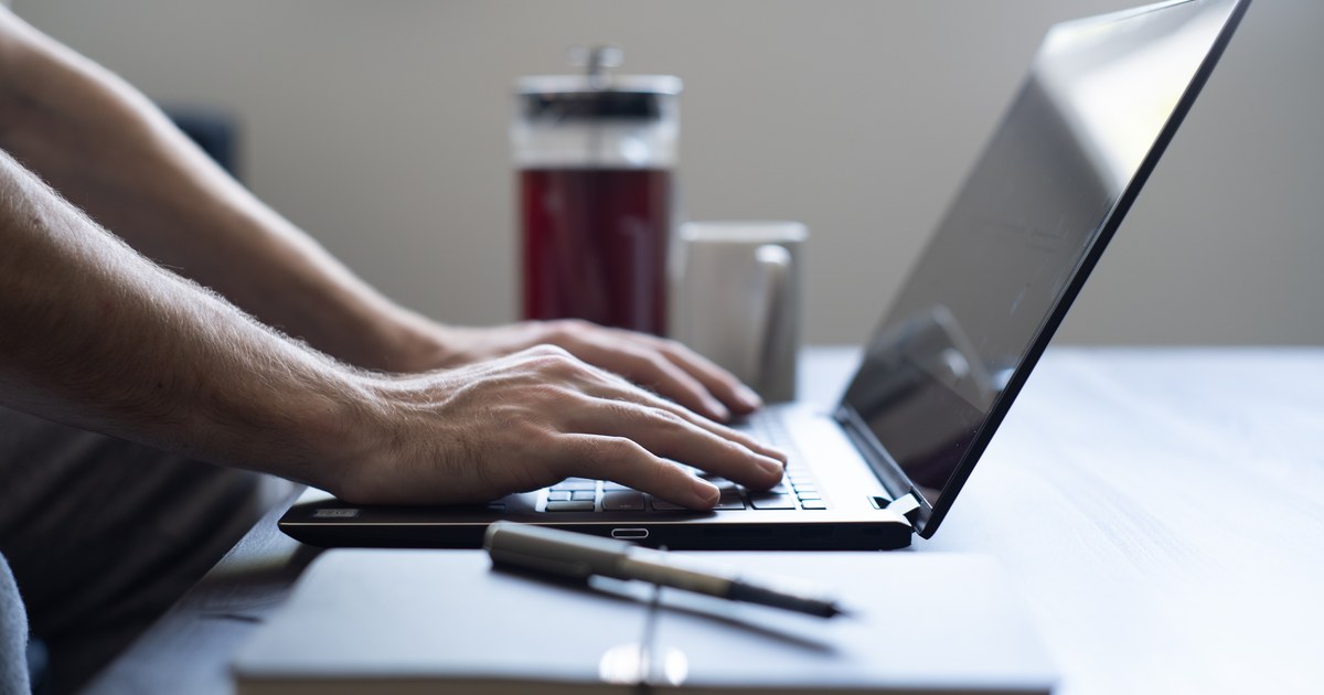 Person typing on a laptop at a desk, illustrating checks before playing at a licensed online casino
