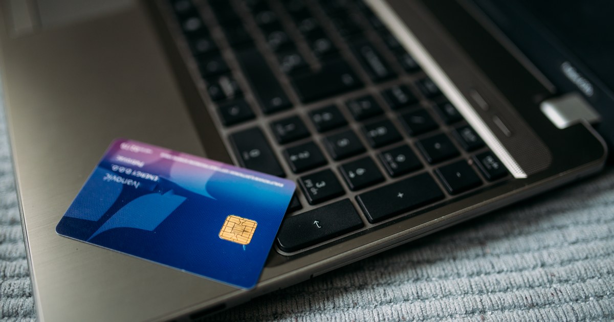 A bank payment card resting on a laptop keyboard, illustrating online casino payments and banking checks.