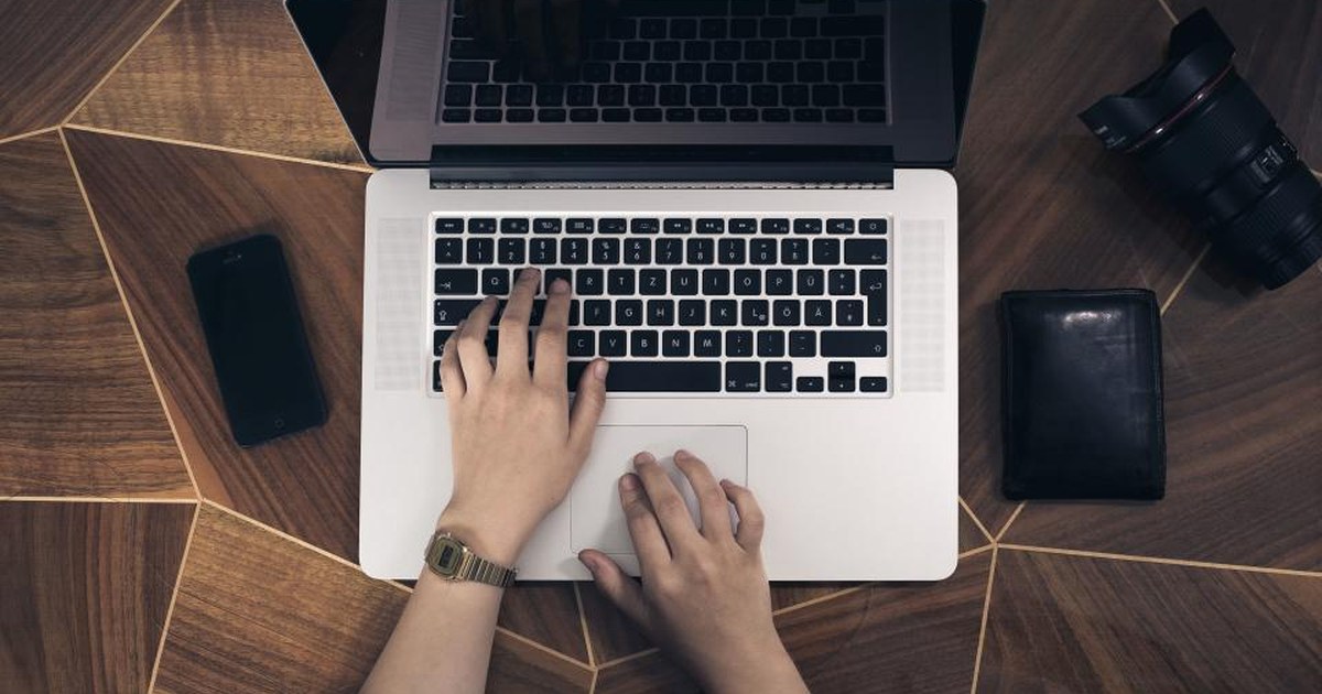 Person using a laptop at a wooden desk, representing online casino play in New Zealand