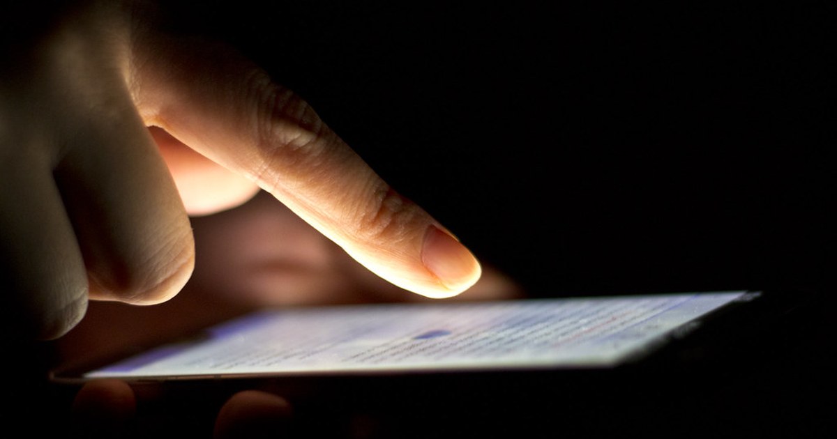 Person checking an account on a smartphone at night