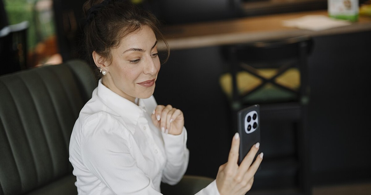 Adult using a smartphone in a cafe to manage an online account on a mobile device