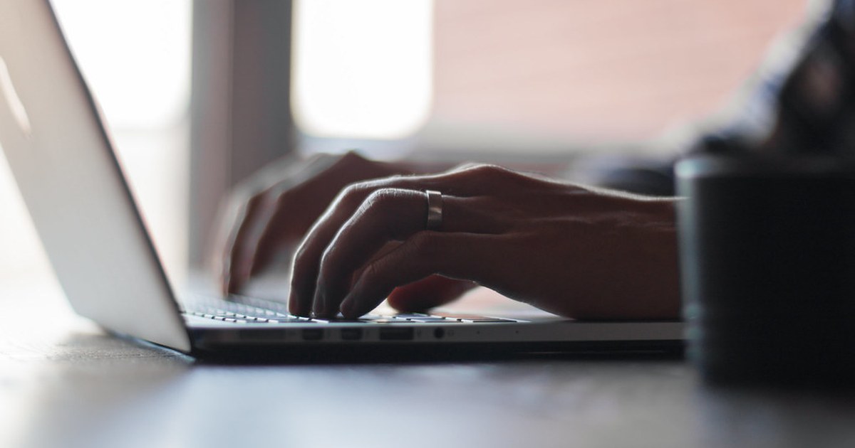 Close-up of a person typing on a laptop at a desk, illustrating how to choose a safe and licensed online casino.