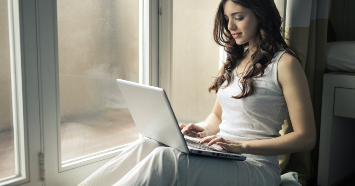 Woman using a laptop at home to research an online casino site